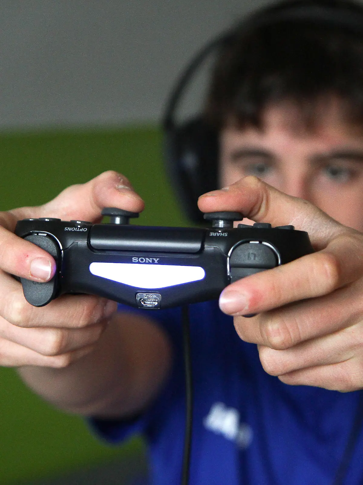 Themenbild - Computerspielen, PC, PC Gaming, Zocken, Controller, Gaming Bild: Model release, Model released Vertrag liegt vor. Eine Person hält einen Controller, PS4 Controller in seinen beiden Händen und spielt, zockt mit einem Kopfhörer ein Computerspiel am Fernseher. Symbolbild, Themenbild, Featurebild Gaming, Game, Gameing, Zocken, PC, Computer, Konsole, XBox, Box, Controller, PS4, PS5, Joystick, Stick, Videospiel, Fortnite, Mindcraft, Fifa, Starwars, Star Wars, Among us, Wii, Wifi, Netzwerk, Soziale, Sozial, Social Network, Social, Network, Maus, Mouse, Tastatur, virtuell, Fernbedienung, Jugendlicher, Kind, zuhause, im Zimmer, Zimmer, Kinderzimmer, Playstation, Play, Station, Beschäftigung, Aktivität, Alter, 20 Jahre, männlich, Bundesrepublik Deutschland, Console, Detail, Innen, Innenaufnahme, Computerspiel, Deutschland, eine Person, ein Mensch, einzelne Person, einzelner Mensch, Elektronik, elektronisch, Europa, Europäische, Abstammung, Freizeit, Freizeitaktivität, Freizeitbeschäftigung, pad, Gamer, Hand, Finger, Hobby, Gamepad, hören, Joypad, Kopfhörer, Headset, Head, set, Mensch, Mitteleuropa, Person, Rechner, TV, Fernsehgerät, Fernseher, Fernsehen, sehen, Sinnbild, Spaß, Spiel, spielen, Spieler, Technik, technisch, Technologie, um Geld spielen, Zentraleuropa, Symbolbild, Themenbild, Feature, Featurebild, Sky, Sky Fernbedienung, Guide, Select, Menue, Menü, Haende, Hände, / Fingernagel, Fingernägel, Mann, maennlich, Junge, einzeln, einzel, allein, Maennerhand, Studio, Studioaufnahme, Remote, Control, Bedienung, bedienen, Tasten, Programm, Programme, Programmwahl, Umschalter, umschalten, Commander, Geraet, TV-Gerät, TV-Geraet, Television, Fuss, Fuß, Fuesse, Füße, Bildschirm, Kaestchen, Kasten, Kästchen, zappen, zapping, wählen, waehlen || Modellfreigabe vorhanden