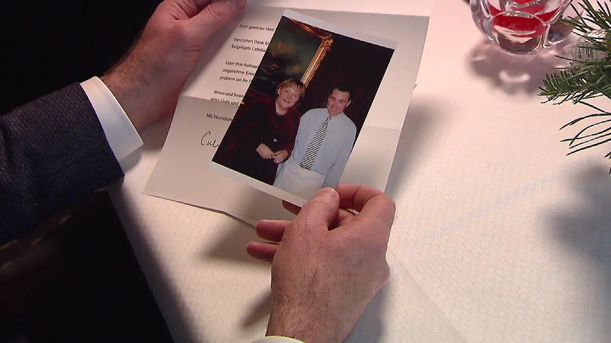 Fischrestautant-Inhaber Dirk Kowalke mit dem Foto und Dankesbrief von Angela Merkel