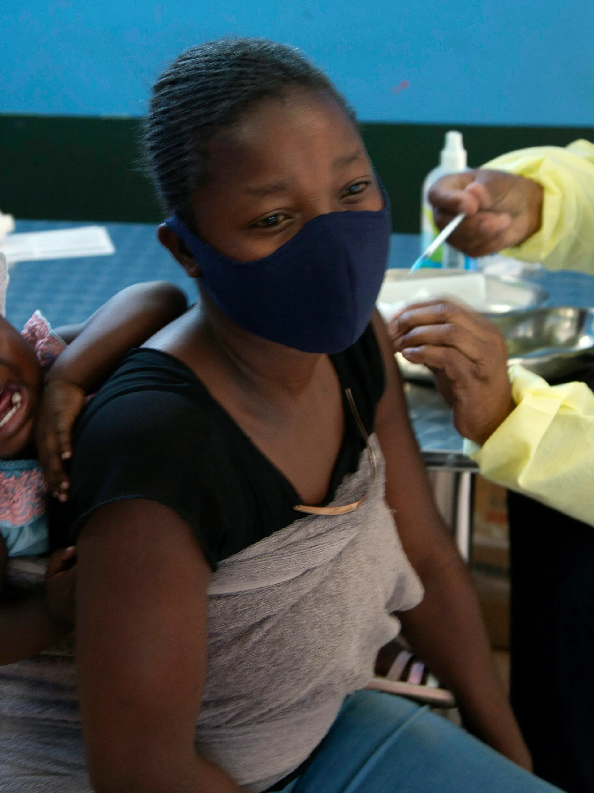 ARCHIV - 21.10.2021, Südafrika, Diepsloot: Ein Baby weint, als seine Mutter am 21.10.2021 im Township Diepsloot in der Nähe von Johannesburg eine Impfung mit dem Impfstoff von Pfizer/Biontech gegen Covid-19 erhält. Die Ausbreitung einer neuen möglicherweise sehr gefährlichen Variante des Coronavirus im südlichen Afrika hat international Besorgnis ausgelöst. Experten befürchten, dass die Variante B.1.1.529 wegen ungewöhnlich vieler Mutationen nicht nur hoch ansteckend sei, sondern auch den Schutzschild der Impfstoffe leichter durchdringen könnte. (Zu dpa «Neue Corona-Supervariante im Süden Afrikas») Foto: Denis Farrell/AP/dpa +++ dpa-Bildfunk +++