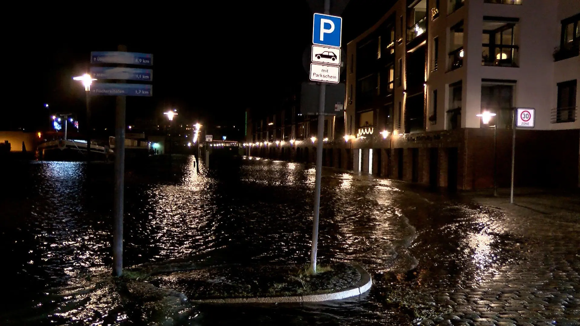 01.12.2021, Bremen, Bremerhaven: Ein Parkplatz ist überflutet. Sturmtief Daniel beschert vor allem Norddeutschland am Abend stürmisches Wetter. An der Küste sind Orkanböen möglich. Foto: -/Nord-West-Media TV/dpa +++ dpa-Bildfunk +++