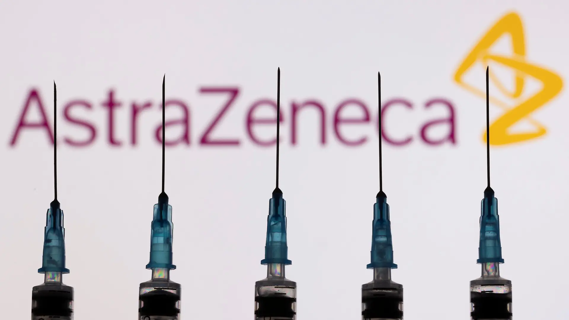 Syringes with needles are seen in front of a displayed AstraZeneca logo in this illustration taken, November 27, 2021. REUTERS/Dado Ruvic/Illustration