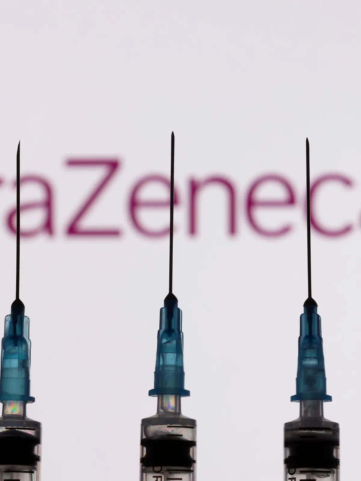 Syringes with needles are seen in front of a displayed AstraZeneca logo in this illustration taken, November 27, 2021. REUTERS/Dado Ruvic/Illustration