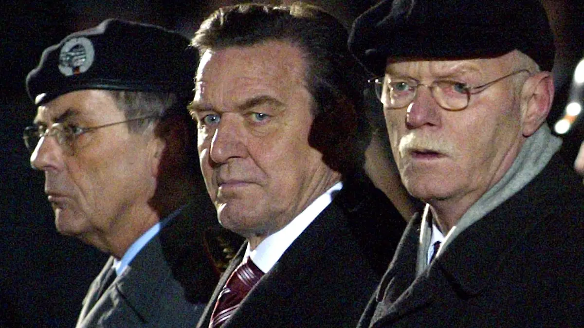 Der scheidende Bundeskanzler Gerhard Schröder (SPD, M) steht am Samstag (19.11.2005) neben dem Bundesverteidigungsminister Peter Struck (SPD, r) und dem Generalinspekteur der Bundeswehr, General Wolfgang Schneiderhan (l) beim Großen Zapfenstreich auf dem Rathausplatz in Hannover. Mit dieser feierlichsten Form eines militärischen Zeremoniells in der Bundesrepublik Deutschland ehrt und verabschiedet die Bundeswehr den scheidenden Bundeskanzler nach seiner sieben Jahren langen Amtszeit. Foto: Jens Wolf dpa/lni +++(c) dpa - Bildfunk+++