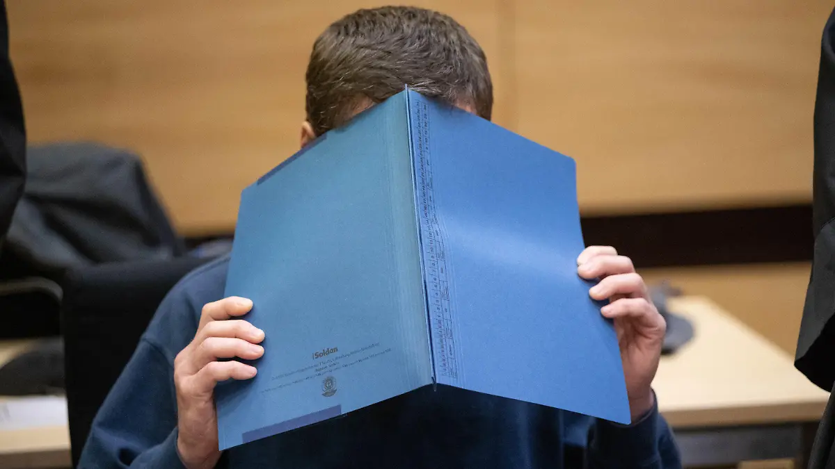 ARCHIV - 15.11.2018, Nordrhein-Westfalen, Bielefeld: Der Angeklagte sitzt mit einer Mappe vor dem Gesicht im Gerichtssaal. Der Mann soll mehrere seiner Arbeitskollegen über Jahre in einem Betrieb in Schloß Holte-Stukenbrock mit gefährlichen Substanzen auf deren Pausenbroten vergiftet haben. Foto: Friso Gentsch/dpa +++ dpa-Bildfunk +++