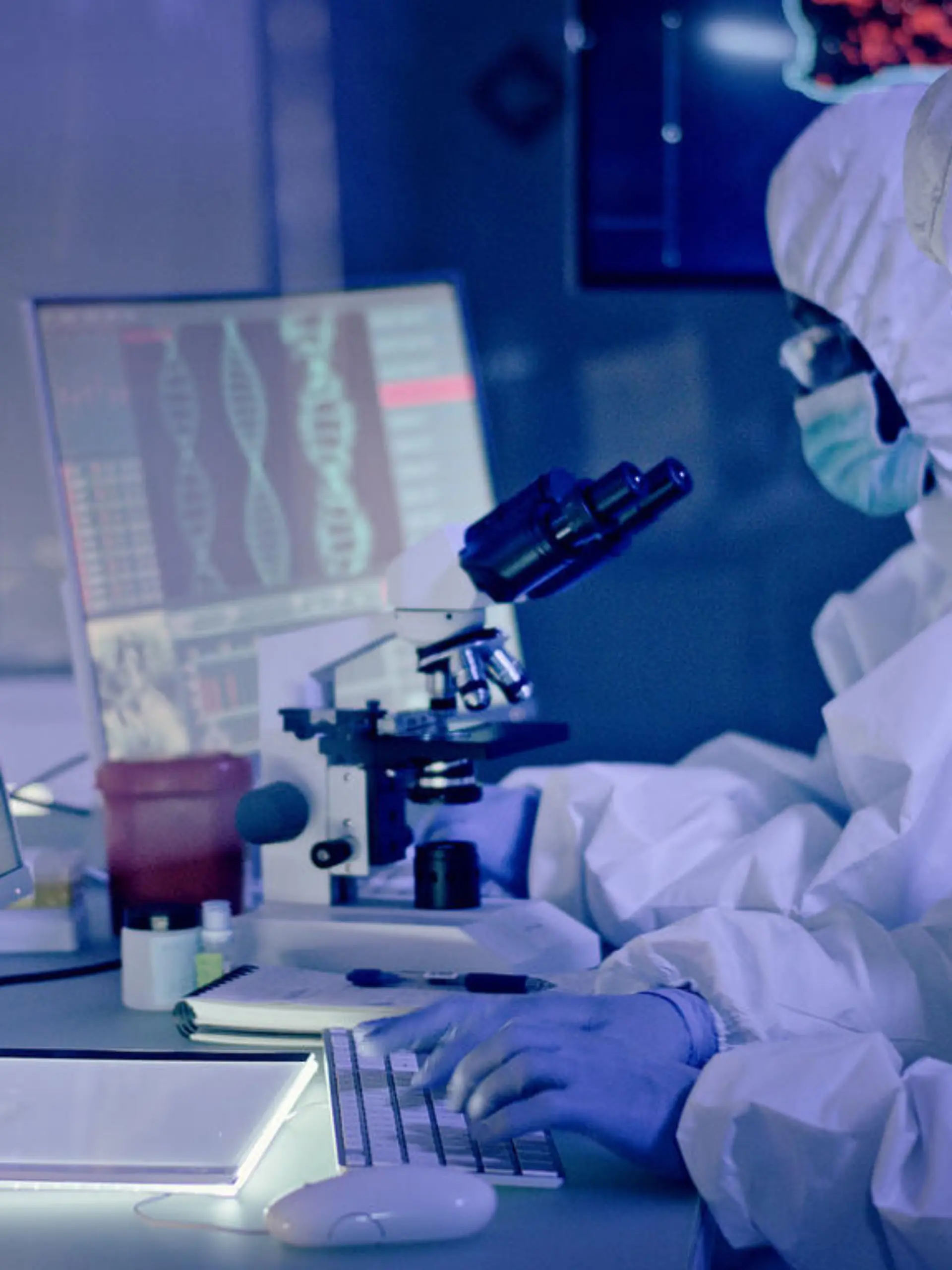 Young multi-ethnic team during coronavirus lab tests. Working on computers. Map of disease outbreaks in background