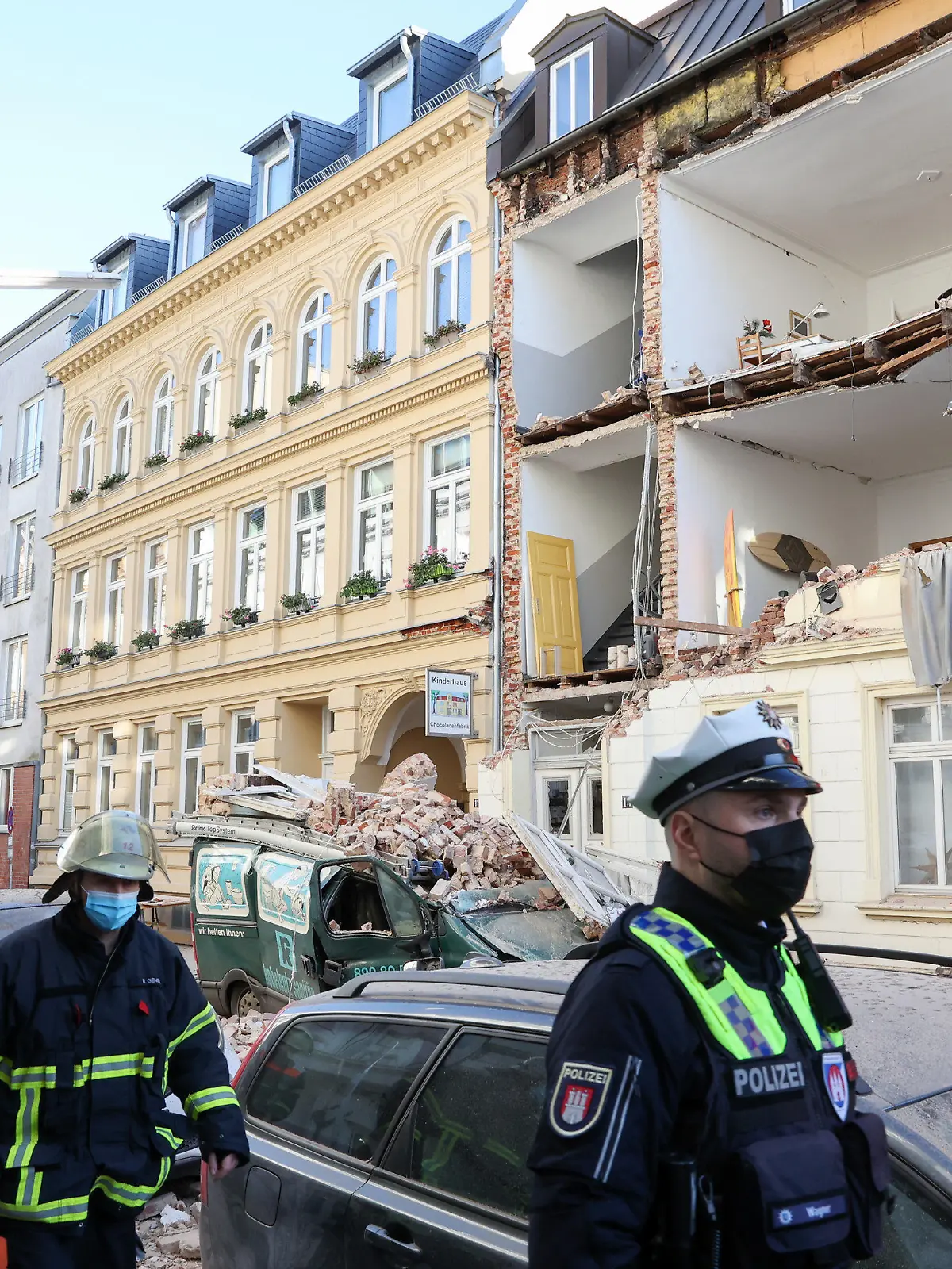 02.12.2021, Hamburg: Polizisten stehen vor einem Haus, dessen Fassade eingestürzt ist. Vermutlich wegen einer Explosion oder einer Verpuffung ist die Fassade eines Wohnhauses im Hamburger Stadtteil Ottensen am Morgen fast komplett eingestürzt. Foto: Bodo Marks/dpa +++ dpa-Bildfunk +++