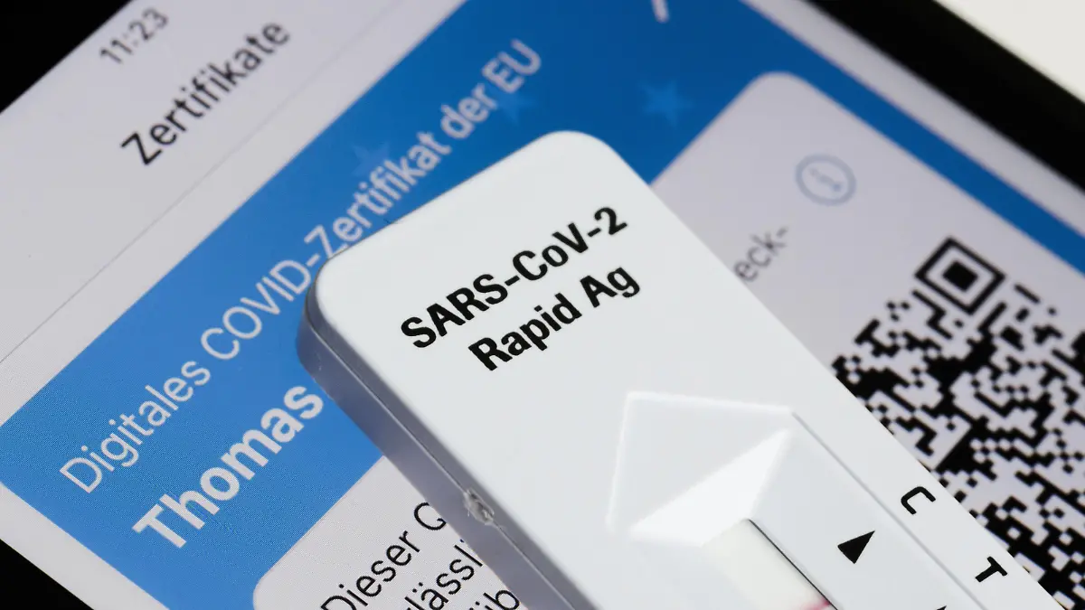 Ein negativer SARS-CoV-2 Rapid Ag Antigen Schnelltest liegt einem Smartphone, welches ein digitales COVID-Zertifikat der EU anzeigt. Berlin, 03.11.2021 Berlin Deutschland *** A negative SARS CoV 2 Rapid Ag Antigen rapid test is on a smartphone displaying an EU digital COVID certificate Berlin, 03 11 2021 Berlin Germany Copyright: xThomasxTrutschel/photothek.dex