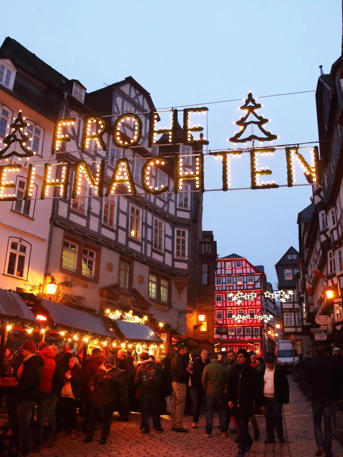  Adventsmarkt am Marktplatz in Marburg am 14.12.2016 Marburg: Stimmungsvolle weihnachtliche Kulisse im Bereich des historischen Rathauses. Zahlreiche Händler, Kunsthandwerker und Künstler sorgen für einen erlebnisreichen bunten Adventsmarkt sowie kulinarische Produkte überwiegend aus der Region für das leibliche Wohl. - Glühweinstand auch ein beliebter Treffpunkt von Studenten - Lichterkette mit Schriftzug: FROHE WEIHNACHTEN Adventsmarkt in Marburg 2016