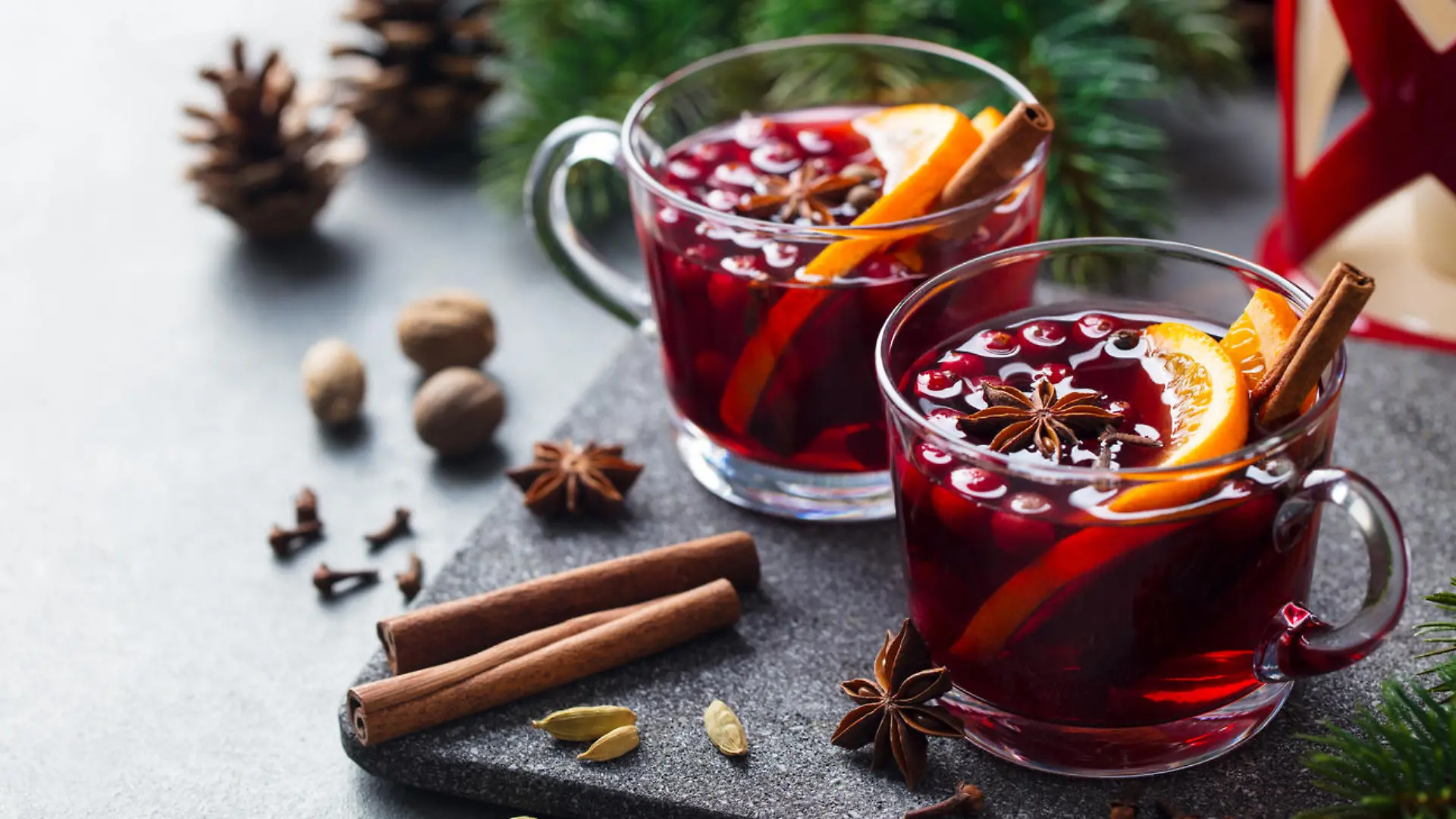 Mulled red wine with spices. Christmas decoration. Grey stone background. Close up.