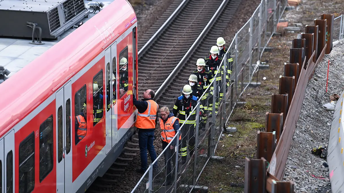 01.12.2021, Bayern, München: Feuerwehrleute gehen zusammen mit Bahnbediensteten nahe der Donnersbergerbrücke zu einer S-Bahn. Nach einem lauten Knall in der Nähe der Brücke läuft ein Polizeieinsatz. «Wir wissen von einem Knall und einer Rauchsäule», sagte ein Polizeisprecher am Mittwoch. Die Feuerwehr sprach in einer ersten Mitteilung von einer Verpuffung. Informationen zu möglichen Verletzten gab es zunächst nicht. Foto: Sven Hoppe/dpa +++ dpa-Bildfunk +++