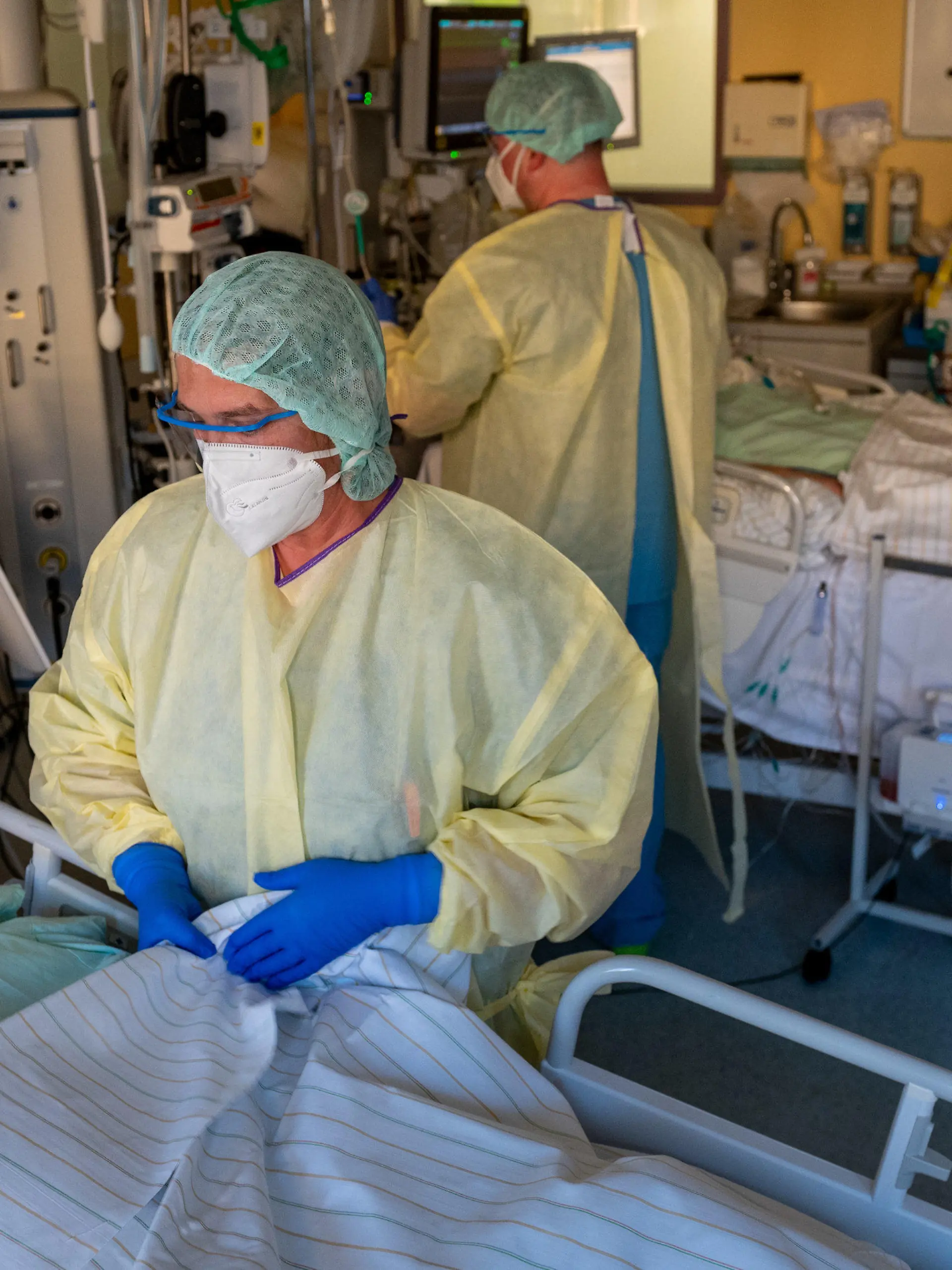 22.11.2021, Sachsen-Anhalt, Halle (Saale): Eine Intensivpflegerin (vorne) versorgt einen schwer an Covid-19 erkrankten Patienten auf der Corona- Intensivstation im Universitätsklinikum in Halle/Saale. Das Krankenhaus ist ein Zentrum der Behandlung von Covid-19-Patienten in der Region. (Zu dpa "«Es ist grausam» - Schwerstarbeit auf Corona-Intensivstation") Foto: Hendrik Schmidt/dpa-Zentralbild/dpa +++ dpa-Bildfunk +++
