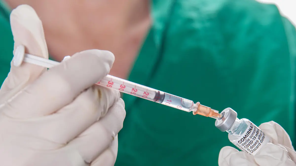 Bamberg, Deutschland 22. November 2021: Eine Person mit Schutzhandschuhen hat mit Hilfe einer Impfspritze eine Impfdosis mit dem mRNA-Impfstoff Comirnaty, BNT162b2, Biontech / Pfizer aus einer Ampulle für die Erstimpfung- Zweitimpfung oder Boosterimpfung aufgezogen gegen das Coronavirus Covid 19. Bayern *** Bamberg, Germany 22 November 2021 A person wearing protective gloves drew up a vaccine dose with the mRNA vaccine Comirnaty, BNT162b2, Biontech Pfizer from an ampoule for primary vaccination secondary vaccination or booster vaccination against the coronavirus Covid 19 Bavaria with the help of a vaccination syringe. Copyright: xFotostandx/xK.xSchmittx