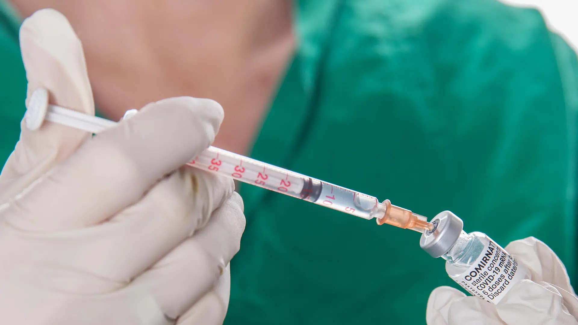Bamberg, Deutschland 22. November 2021: Eine Person mit Schutzhandschuhen hat mit Hilfe einer Impfspritze eine Impfdosis mit dem mRNA-Impfstoff Comirnaty, BNT162b2, Biontech / Pfizer aus einer Ampulle für die Erstimpfung- Zweitimpfung oder Boosterimpfung aufgezogen gegen das Coronavirus Covid 19. Bayern *** Bamberg, Germany 22 November 2021 A person wearing protective gloves drew up a vaccine dose with the mRNA vaccine Comirnaty, BNT162b2, Biontech Pfizer from an ampoule for primary vaccination secondary vaccination or booster vaccination against the coronavirus Covid 19 Bavaria with the help of a vaccination syringe. Copyright: xFotostandx/xK.xSchmittx