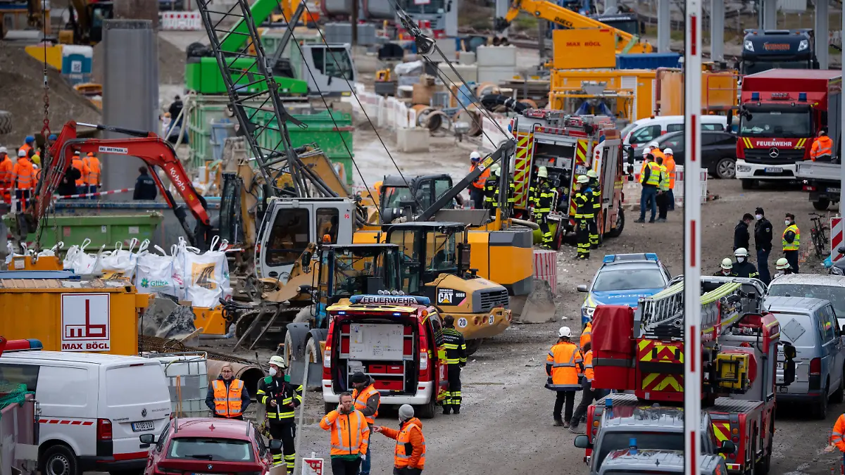 01.12.2021, Bayern, München: Feuerwehrleute, Polizisten und Bahnbedienstete stehen auf einem Bahngelände an der Donnersbergerbrücke. Bei der Explosion einer Fliegerbombe aus dem Zweiten Weltkrieg sind an der Bahnstrecke zum Hauptbahnhof in München mehrere Menschen verletzt worden. Der gesamte Zugverkehr zum und vom Hauptbahnhof wurde stundenlang eingestellt. Foto: Sven Hoppe/dpa +++ dpa-Bildfunk +++