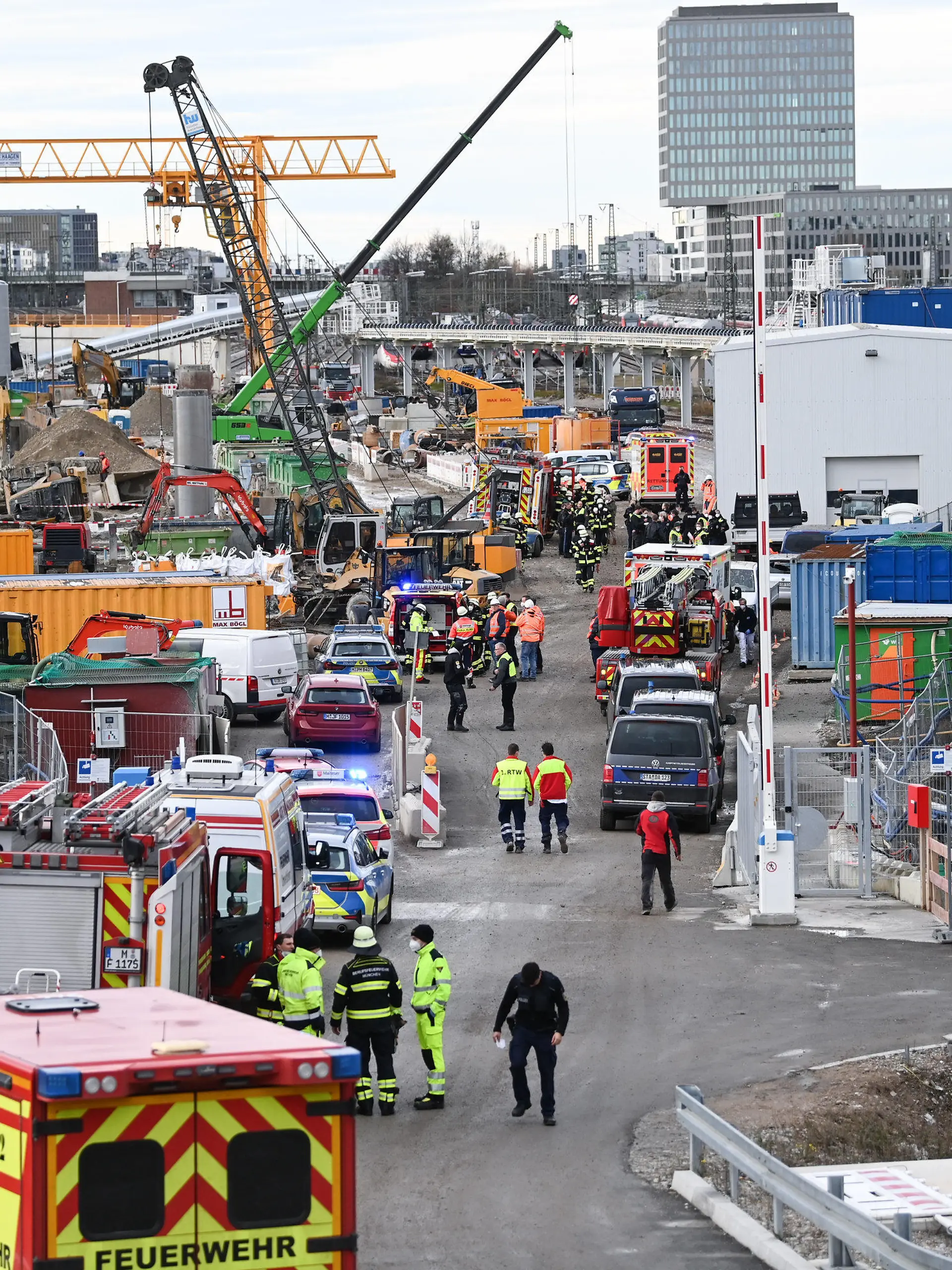01.12.2021, Bayern, München: Feuerwehrleute, Polizisten und Bahnbedienstete stehen auf einem Bahngelände an der Donnersbergerbrücke. Bei einer Explosion auf einer Baustelle der Deutschen Bahn sind nach Angaben der Feuerwehr drei Menschen verletzt worden. Genauere Angaben gab es zunächst nicht. Nach Auskunft der Polizei hatte es in der Nähe der Donnersbergerbrücke einen lauten Knall gegeben, anschließend bildete sich eine Rauchsäule. Foto: Sven Hoppe/dpa +++ dpa-Bildfunk +++