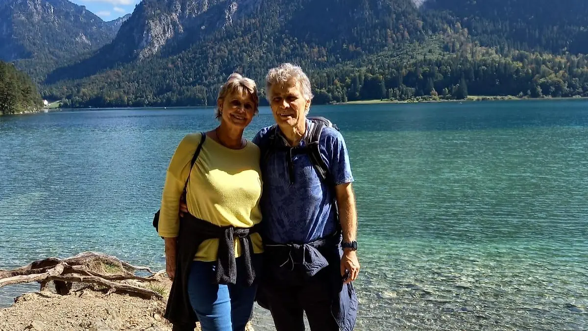 Mann und Frau, die im Tal vor See und Bergen stehen