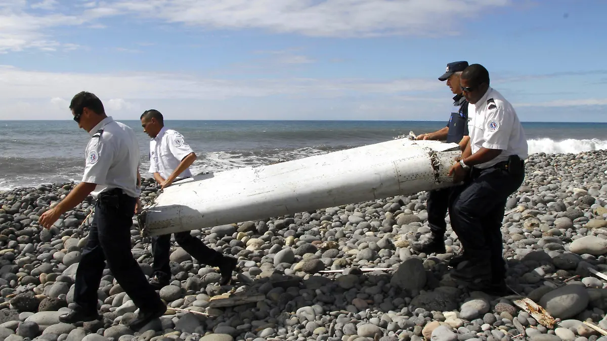 epa04873247 (FILE) A file photo dated 29 July 2015 showing officers carrying a flaperon from an aircraft apparently washed ashore in Saint-Andre de la Reunion, eastern La Reunion island, France. Malaysian Prime Minister NajiB Razak announced 05 August 2015 that the flaperon found on the French Reunion Island a week ago was a part of the missing Malaysia Airlines flight MH370. EPA/RAYMOND WAE TION FRANCE OUT, CORBIS OUT, BELGIUM OUT +++(c) dpa - Bildfunk+++