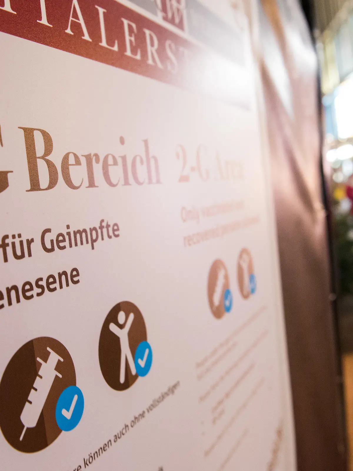 30.11.2021, Hamburg: Passanten gehen durch die Einkaufsstraße «Spitalerstraße». An einem dortigen Weihnachtsmarkt hängt ein Schild mit der Aufschrift «2-G Bereich. Zutritt für Geimpfte und Genesene». Der Hamburger Einzelhandel rechnet wegen der ab Samstag (04.12.2021) geltenden 2G-Regel in der Hansestadt mit Schlangen vor den Geschäften und ausbleibender Kundschaft. Foto: Daniel Bockwoldt/dpa +++ dpa-Bildfunk +++