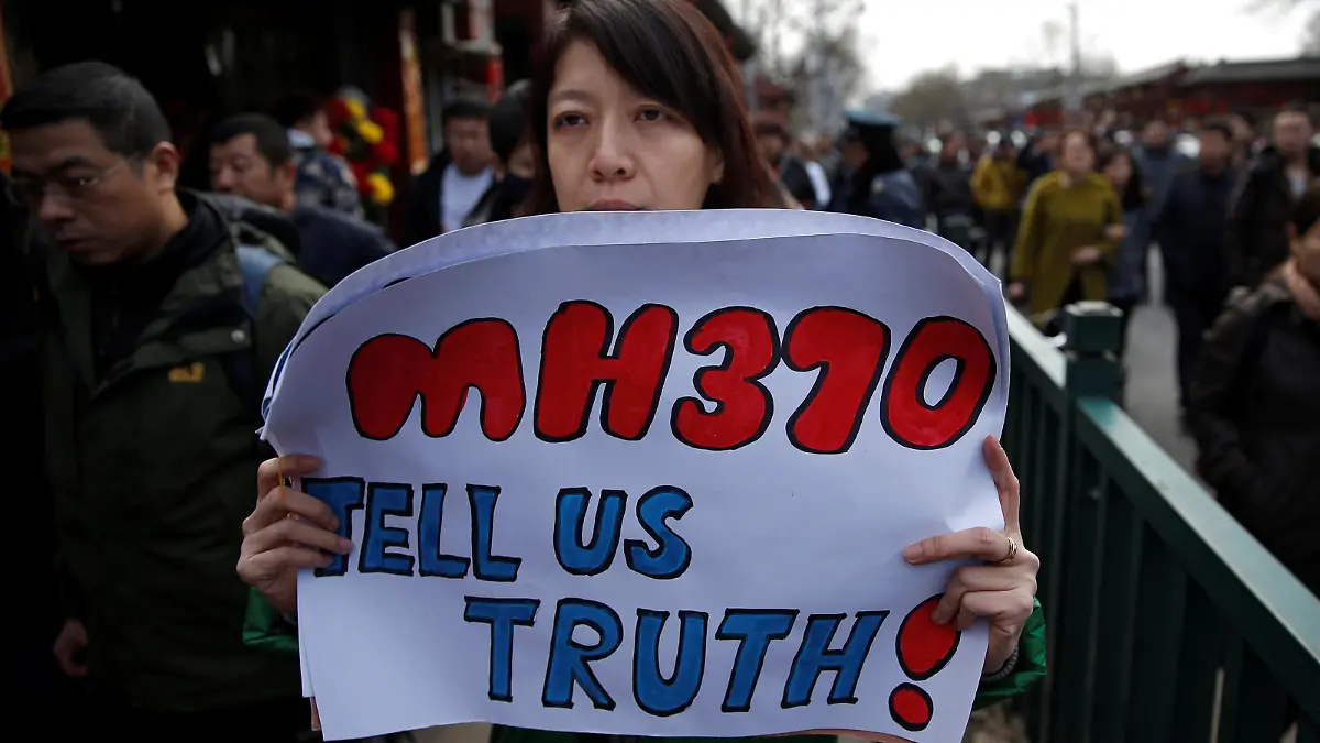 FILE PHOTO: Catherine Gang, whose husband Li Zhi was onboard the missing Malaysia Airlines flight MH370, holds a banner as she walks outside Yonghegong Lama Temple after a gathering of family members of the missing passengers in Beijing March 8, 2015. REUTERS/Kim Kyung-Hoon/File Photo PLEASE SEARCH "FROM THE FILES - 5TH ANNIVERSARY OF MH370 DISAPPEARANCE” FOR ALL PICTURES.