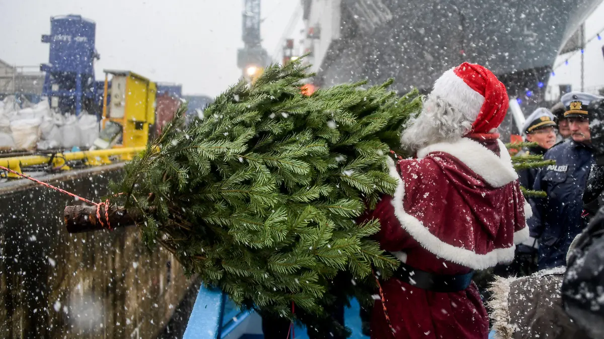 Ein Weihnachtsmann überreicht am 08.12.2017 in Hamburg der Besatzung des Einsatzgruppenversorgers "Berlin" der Bundeswehr einen Weihnachtsbaum. Traditionell werden in jedem Jahr Weihnachtsbäume für die Schiffe im Hamburger Hafen verschenkt. Foto: Axel Heimken/dpa +++(c) dpa - Bildfunk+++