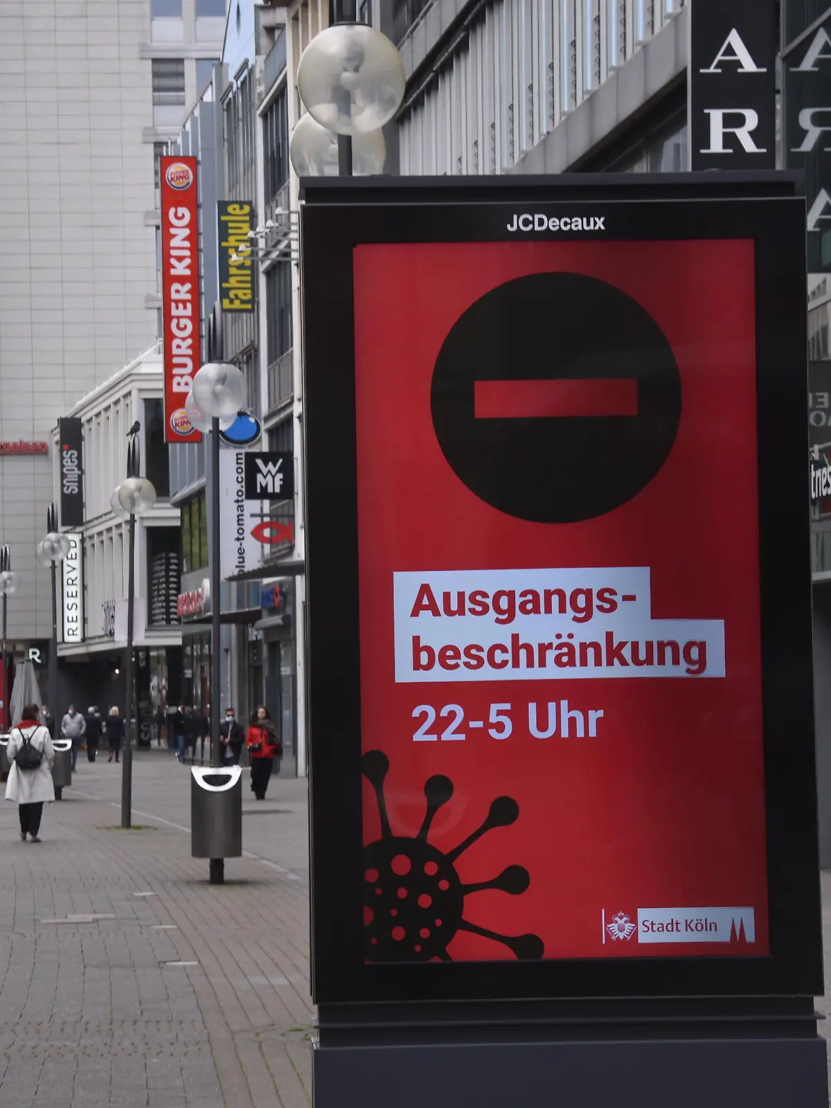 Plakat mit Hinweis auf die nächtliche Ausgangssperre von 22.00 - 05.00 Uhr auf der Schildergasse in Köln.