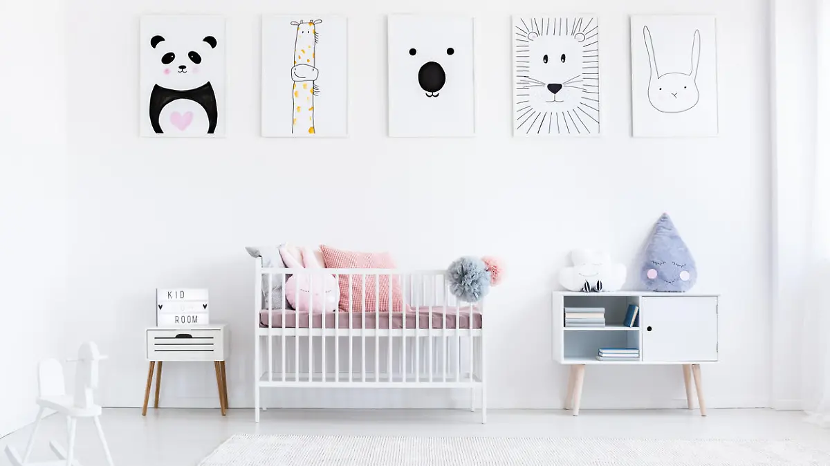 Girl's bedroom with rocking horse and bed with pink pillows against wall with animal posters