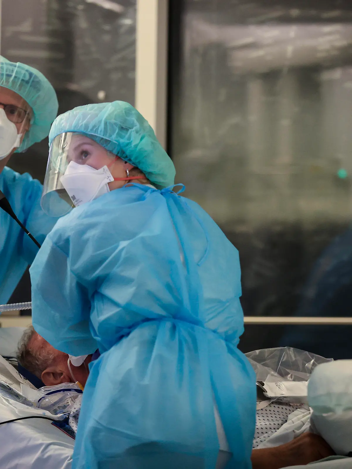 15.11.2021, Sachsen, Leipzig: Ein Facharzt und eine Intensivpflegerin führen eine Bronchoskopie an einem intubierten Covid-19-Patienten auf der Intensivstation der Leipziger Uniklinik durch. ·Aufgrund der steigenden Corona-Infektionszahlen und der damit stark gestiegene Zahl behandlungsbedürftiger Covid-19-Patienten hat das Universitätsklinikum die Zahl der geplanten Operationen um über 30 Prozent verringert. Damit sollen die Kapazitäten für die Behandlung der Corona-Patienten gesichert werden. Foto: Jan Woitas/dpa-Zentralbild/dpa +++ dpa-Bildfunk +++
