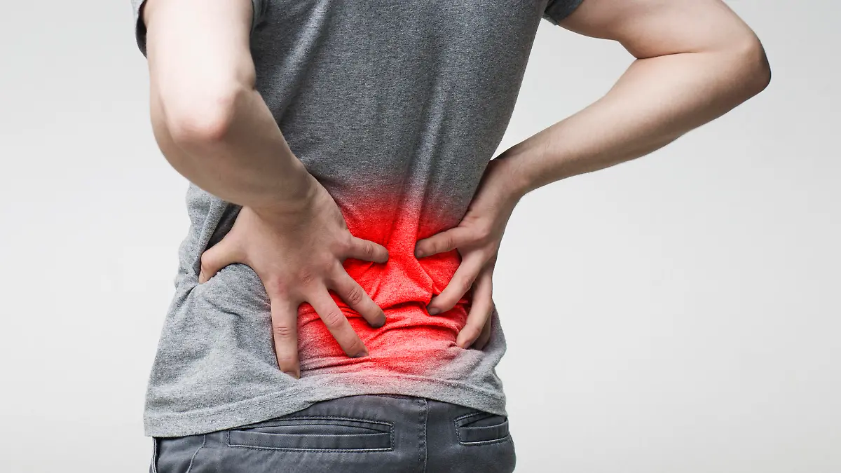 Man holding his hands behind his back, pain in spine, touching red inflamed zone, panorama