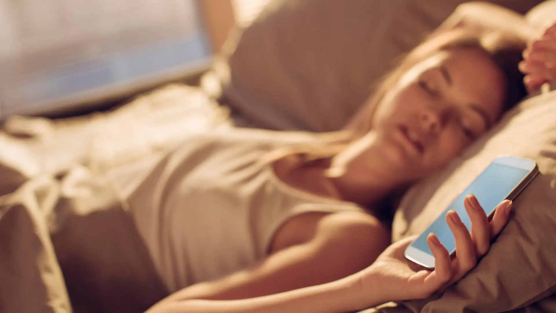 Close up of a young woman fall asleep next to smart phone