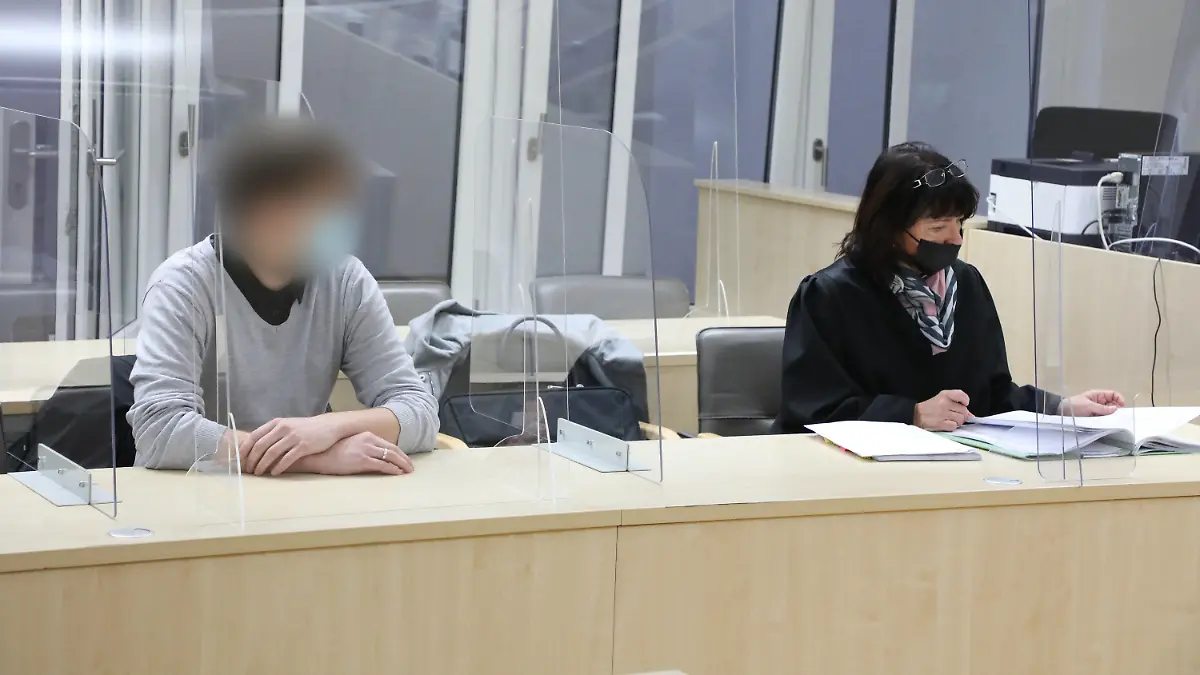 29.11.2021, Thüringen, Gera: Ein junger Mann sitzt in einem Saal des Amtsgerichtes zu Beginn des Prozesses gegen ihn wegen fahrlässiger Tötung neben seiner Verteidigerin Ricarda Holley. Der Angeklagte soll an einem Januartag mit seinem Auto über ein Schneefeld in Gera gedriftet sein, die Kontrolle über sein Fahrzeug verloren habenund dadruch den Tod eine vierjährigen Mädchens verursacht haben, das auf einem Rodelausflug war. Foto: Bodo Schackow/dpa-zentralbild/dpa - ACHTUNG: Der Angeklagte wurde auf Anweisung des Gerichts gepixelt +++ dpa-Bildfunk +++