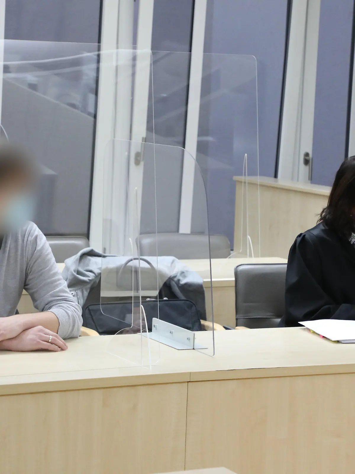 29.11.2021, Thüringen, Gera: Ein junger Mann sitzt in einem Saal des Amtsgerichtes zu Beginn des Prozesses gegen ihn wegen fahrlässiger Tötung neben seiner Verteidigerin Ricarda Holley. Der Angeklagte soll an einem Januartag mit seinem Auto über ein Schneefeld in Gera gedriftet sein, die Kontrolle über sein Fahrzeug verloren habenund dadruch den Tod eine vierjährigen Mädchens verursacht haben, das auf einem Rodelausflug war. Foto: Bodo Schackow/dpa-zentralbild/dpa - ACHTUNG: Der Angeklagte wurde auf Anweisung des Gerichts gepixelt +++ dpa-Bildfunk +++