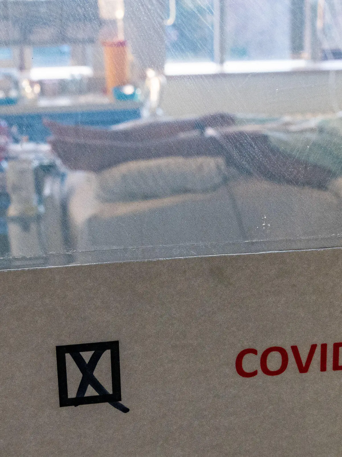 22.11.2021, Sachsen-Anhalt, Halle (Saale): Ein schwer an Covid-19 erkrankter Patient liegt hinter einem Schild mit dem Hinweis ·Covid positiv· in einem Isolierzimmer auf der Corona-Intensivstation im Universitätsklinikum in Halle/Saale. Das Krankenhaus ist ein Zentrum der Behandlung von Covid-19-Patienten in der Region. (Zu dpa "«Es ist grausam» - Schwerstarbeit auf Corona-Intensivstation") Foto: Hendrik Schmidt/dpa-Zentralbild/dpa +++ dpa-Bildfunk +++