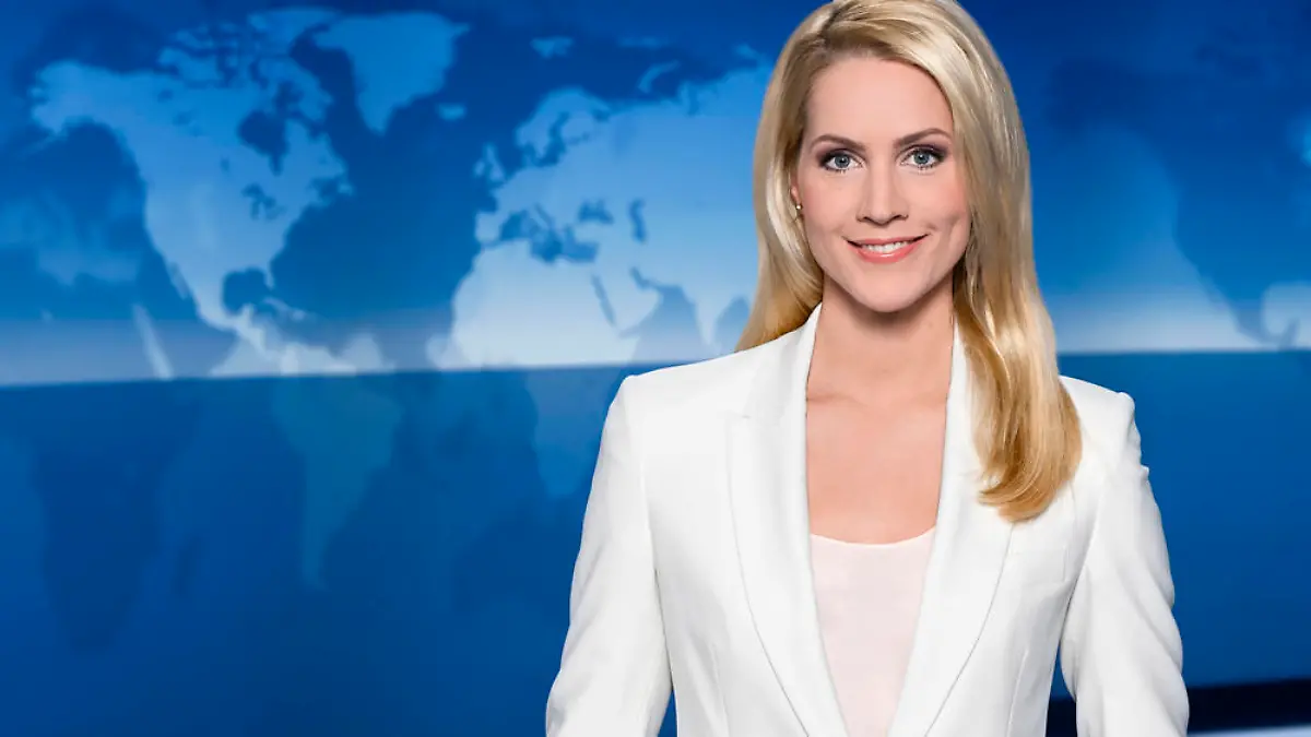 "Tagesschau"-Sprecherin Judith Rakers hebt sich mit ihrem weißen Blazer deutlich vom blauen Hintergrund ab
