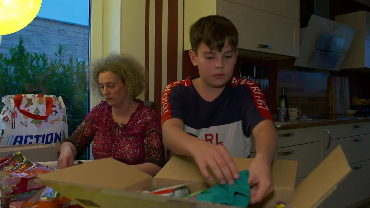 Mutter und Sohn packen ein Päckchen