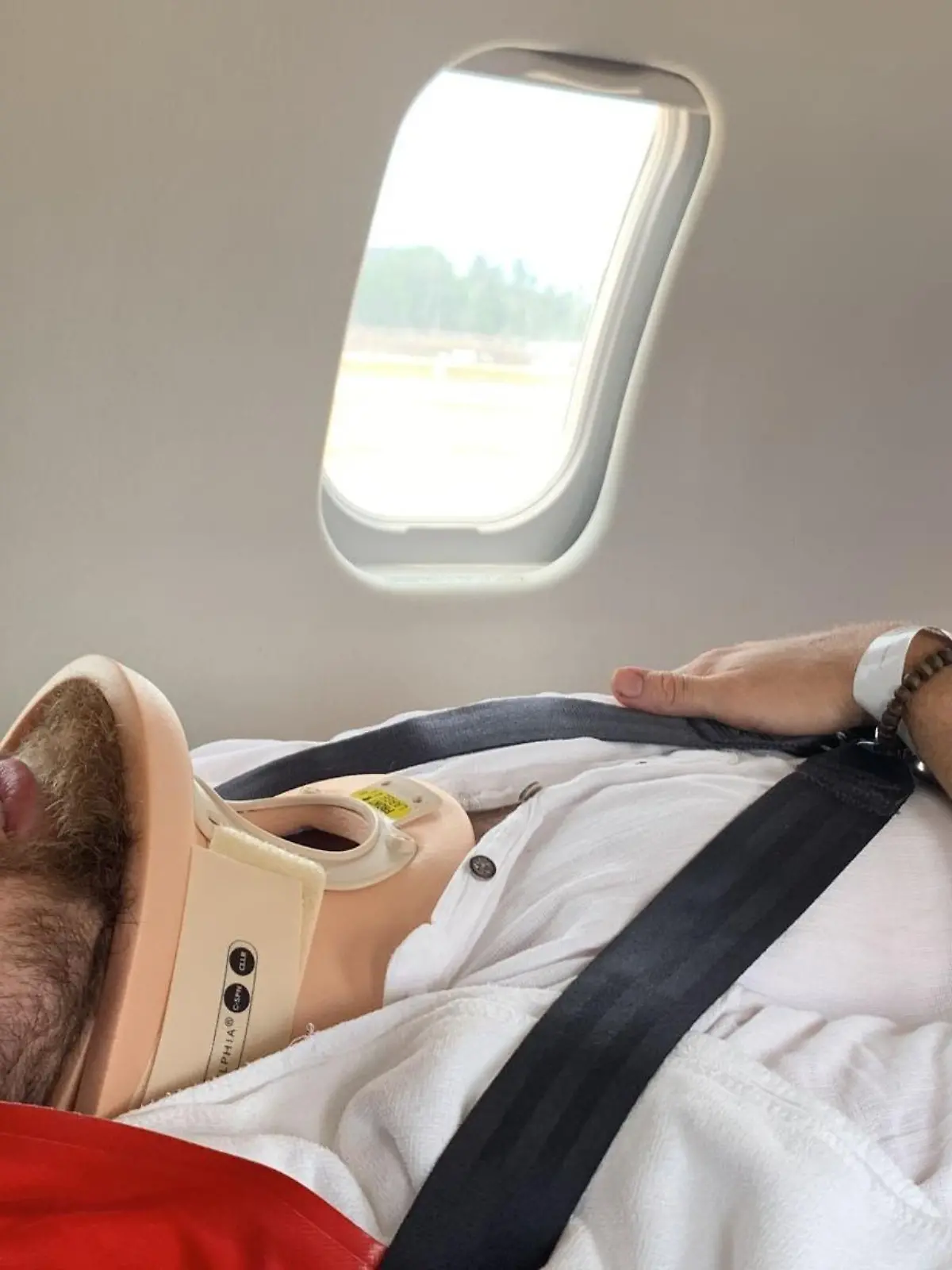 Erik liegt auf der Trage im Krankentransport zurück nach Deutschland.
