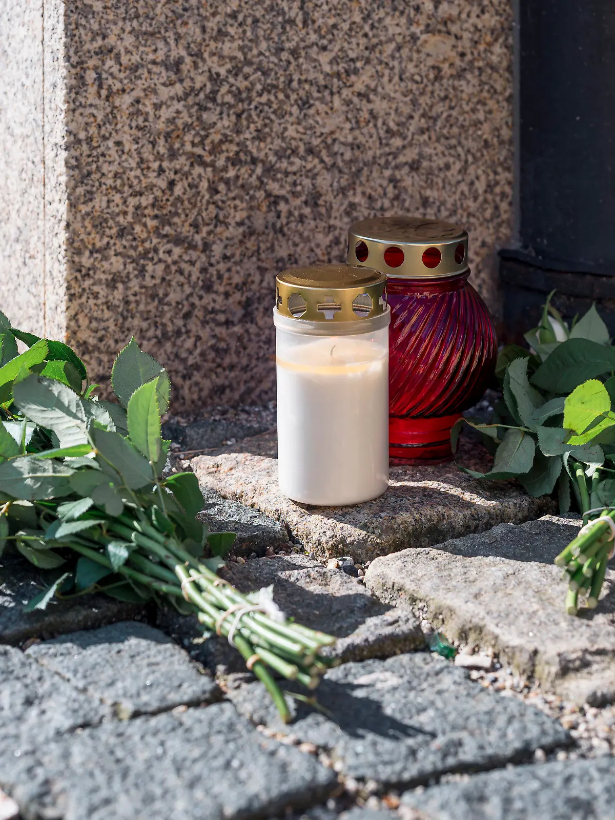 06.04.2023, Bayern, Wunsiedel: An der Straßenecke zur Zufahrtsstraße zum Kinder- und Jugendhilfezentrum, in dem eine Zehnjährige tot aufgefunden wurde, liegen Blumen und Grablichter auf dem Gehweg. Foto: Daniel Vogl/dpa +++ dpa-Bildfunk +++