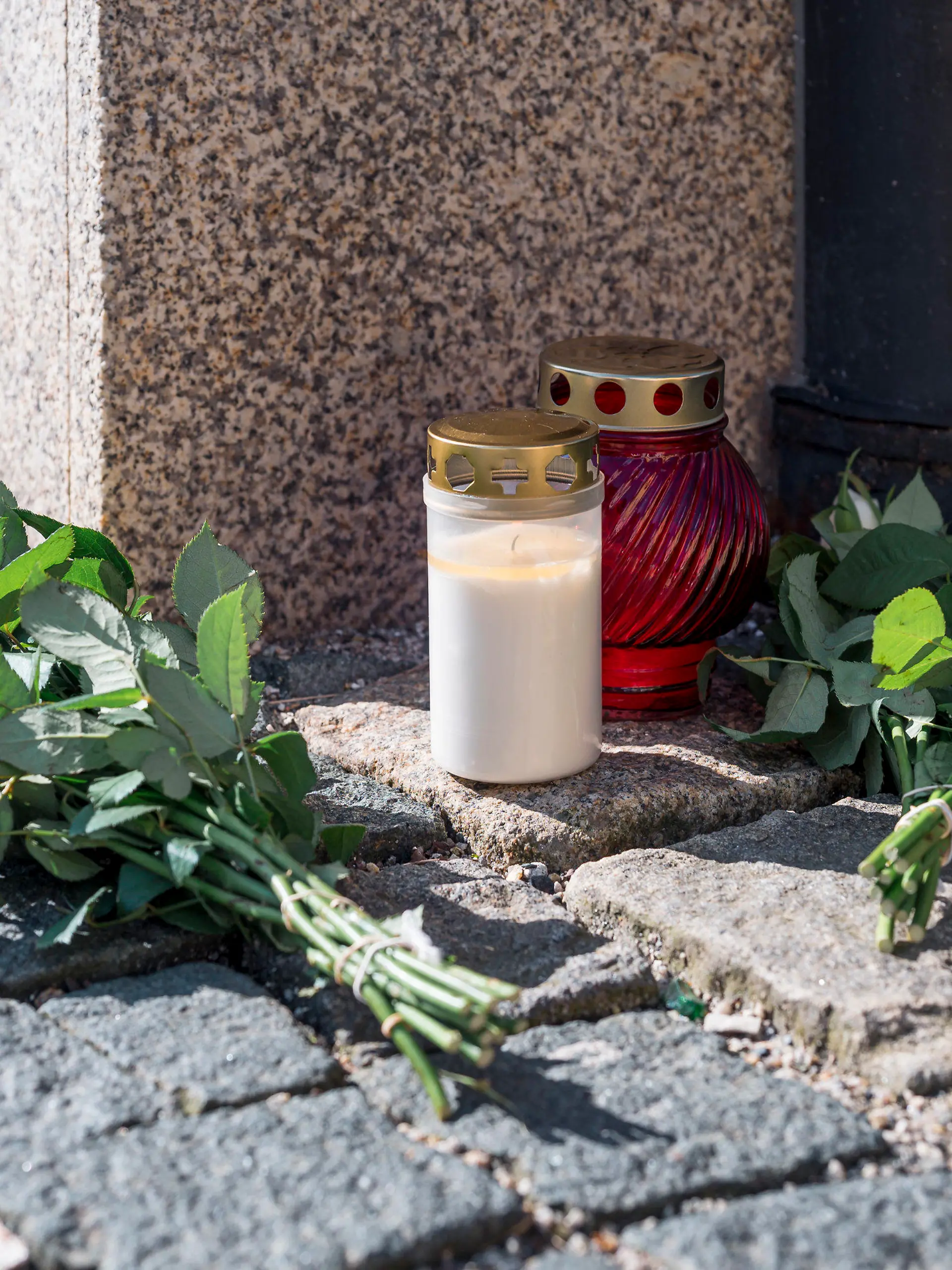 06.04.2023, Bayern, Wunsiedel: An der Straßenecke zur Zufahrtsstraße zum Kinder- und Jugendhilfezentrum, in dem eine Zehnjährige tot aufgefunden wurde, liegen Blumen und Grablichter auf dem Gehweg. Foto: Daniel Vogl/dpa +++ dpa-Bildfunk +++