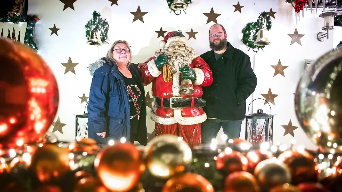 23.11.2021, Niedersachsen, Delmenhorst: Martina und Sven Borchart stehen vor ihrem weihnachtlich geschmückten Haus. Lange hat die Familie Borchart gebastelt und geschmückt. Nun ist ihr Haus bis in die Dachspitze hinein mit Lichtern versehen. (zu dpa Weihnachtshaus in Delmenhorst leuchtet wieder) Foto: Sina Schuldt/dpa +++ dpa-Bildfunk +++