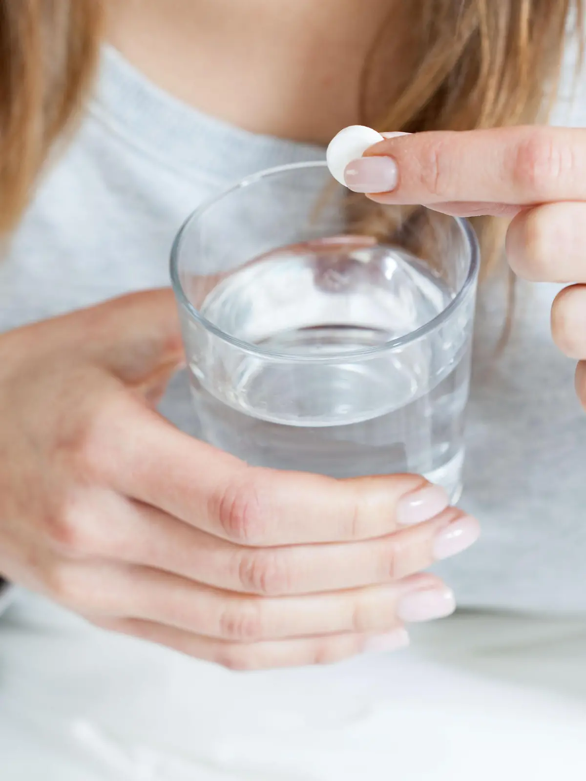 Horizontal view of ill woman taking aspirin