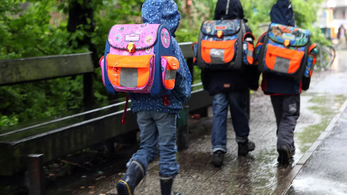 19.05.2010, Berlin, Deutschland - Kinder bei Regenwetter auf dem Weg zur Schule. (QF, Rückansicht, Schüler, Grundschüler, Rücken, Haltungsschäden, Nässe, europäisch) 00S100519D004.JPG MODEL RELEASE: NO, PROPERTY RELEASE: NO MR:N