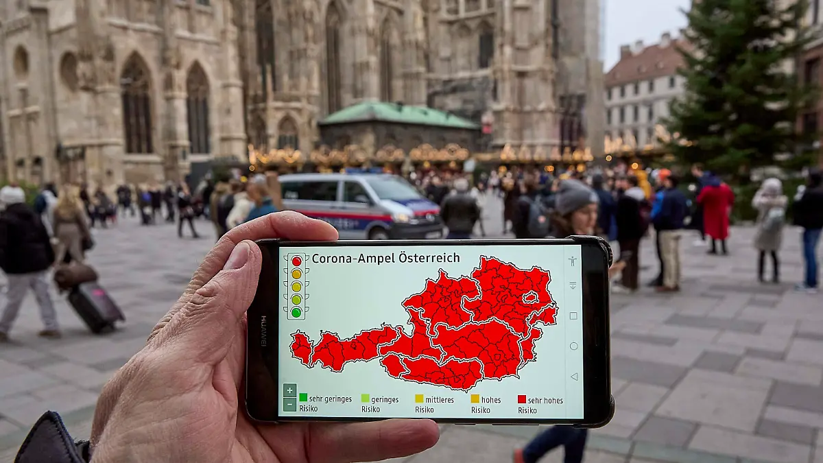  - Wien 12.11.2021 - Coronavirus Krise - Kurz vor Beginn der Wintersaison stuft Deutschland Österreich seit heute wieder als Hochrisikogebiet ein. Das teilte Deutschlands Gesundheitsminister Jens Spahn CDU heute mit. Personen, die weder geimpft noch genesen sind, müssen nach einem Aufenthalt in Österreich nach der Einreise in Deutschland in zehntägige Quarantäne. Die stark steigenden Infektionszahlen in Österreich sind mit ein Grund für die Reisewarnung. Der Bundeskanzler wird am Sonntag einen bundesweiten Lockdown für Ungeimpfte verkünden. PHOTO: Die Corona-Ampel steht auf Rot für ganz Österreich, regionale Lockdowns stehen bevor. In der Wiener Innenstadt herrscht trotzdem reges Treiben wie hier auf dem Weihnachtsmarkt vor dem Stephans PUBLICATIONxNOTxINxAUT