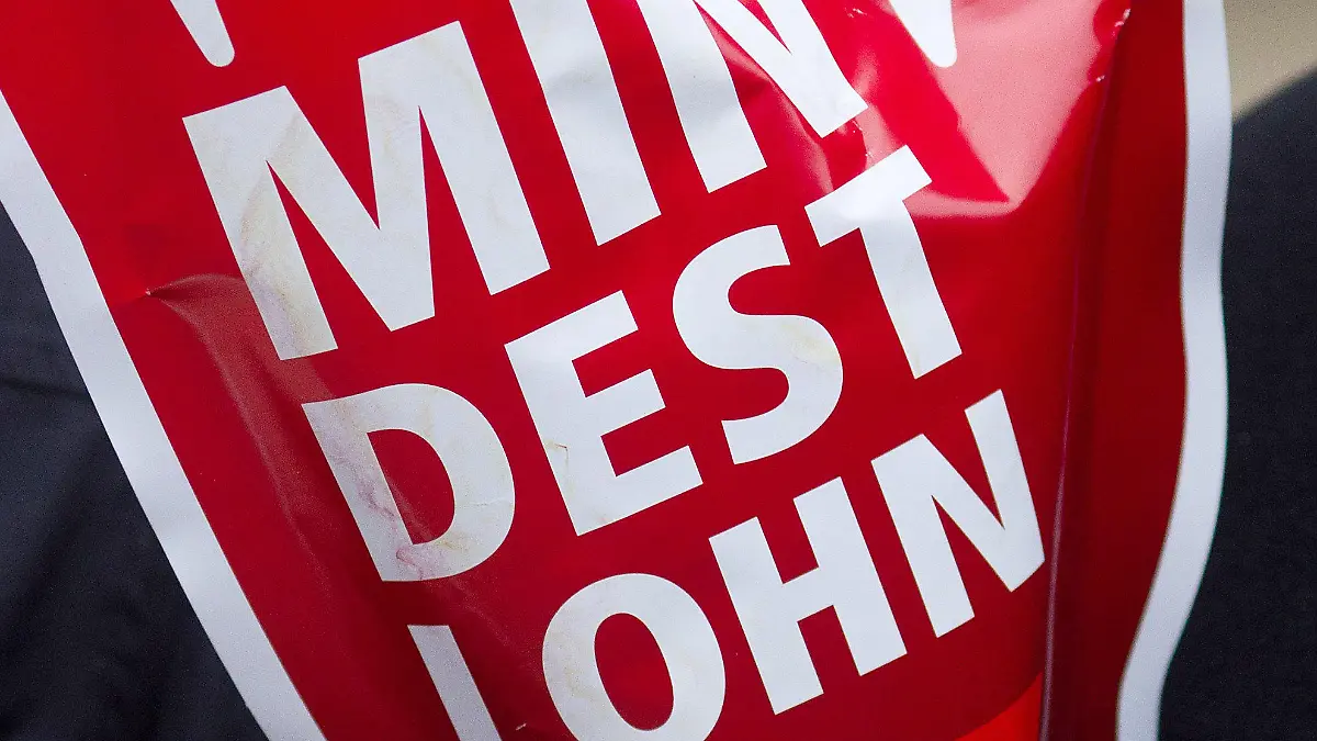 ARCHIV - 29.02.2012, Magdeburg: Ein Schild in Form einer roten Hand mit der Aufschrift «Mindestlohn» wird während einer Aktion des Deutschen Gewerkschaftsbundes (DGB) hochgehalten. SPD, Grüne und FDP wollen den gesetzlichen Mindestlohn auf 12 Euro pro Stunde erhöhen. Foto: Jens Wolf/dpa +++ dpa-Bildfunk +++