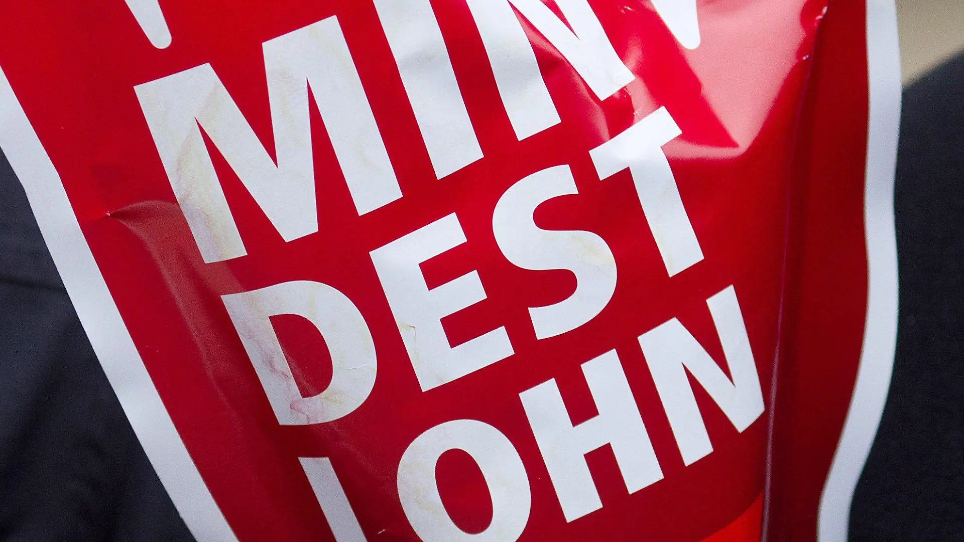 ARCHIV - 29.02.2012, Magdeburg: Ein Schild in Form einer roten Hand mit der Aufschrift «Mindestlohn» wird während einer Aktion des Deutschen Gewerkschaftsbundes (DGB) hochgehalten. SPD, Grüne und FDP wollen den gesetzlichen Mindestlohn auf 12 Euro pro Stunde erhöhen. Foto: Jens Wolf/dpa +++ dpa-Bildfunk +++