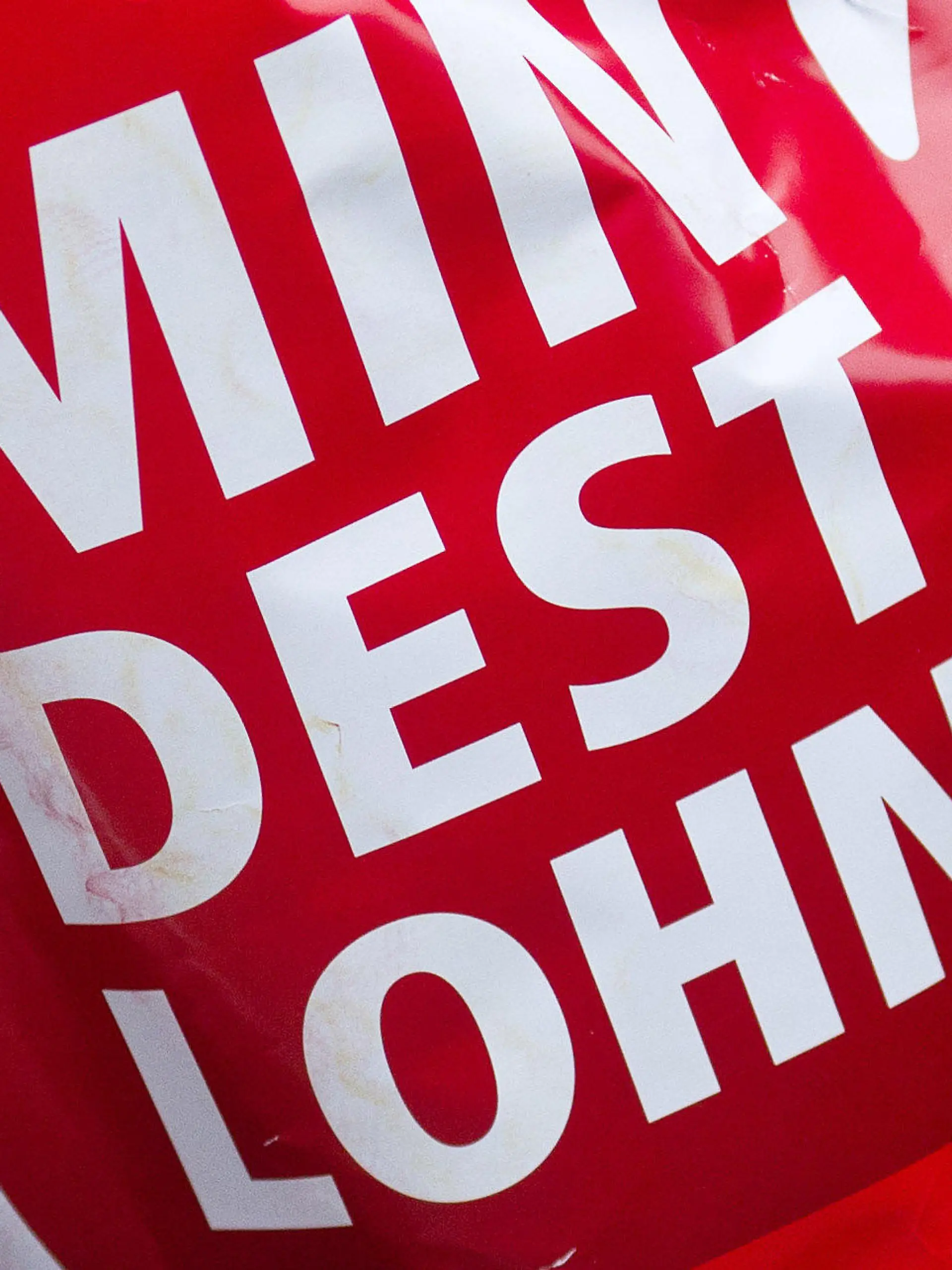 ARCHIV - 29.02.2012, Magdeburg: Ein Schild in Form einer roten Hand mit der Aufschrift «Mindestlohn» wird während einer Aktion des Deutschen Gewerkschaftsbundes (DGB) hochgehalten. SPD, Grüne und FDP wollen den gesetzlichen Mindestlohn auf 12 Euro pro Stunde erhöhen. Foto: Jens Wolf/dpa +++ dpa-Bildfunk +++