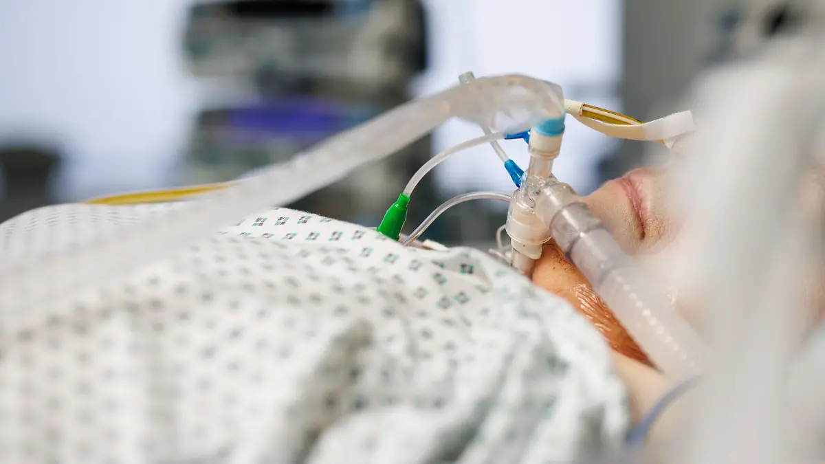 19.11.2021, Bayern, Gauting: Ein über einen Luftröhrenschnitt beatmeter Corona-Patient liegt in einem Intensivbett-Zimmer in der Asklepios Klinik. Foto: Matthias Balk/dpa +++ dpa-Bildfunk +++