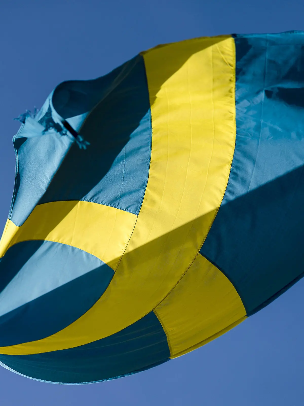 ARCHIV - 09.04.2017, Schweden, Jönköping: Die schwedische Flagge weht vor blauem Himmel im Wind. In Schweden ist die Wirtschaftskraft wegen der Corona-Krise zwar drastisch gesunken, der konjunkturelle Rückschlag war in den Monaten April bis Juni 2020 aber weniger schlimm als in anderen europäischen Staaten. Foto: Jonas Ljungdahl/Bildbyran via ZUMA Wire/dpa +++ dpa-Bildfunk +++