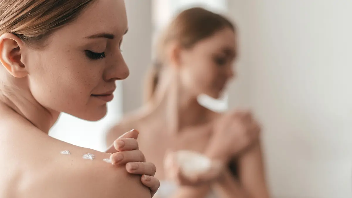 Frau cremt sich ein.