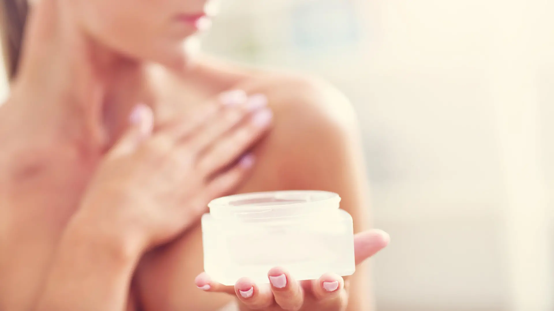 Picture showing fit woman holding lotion over her body