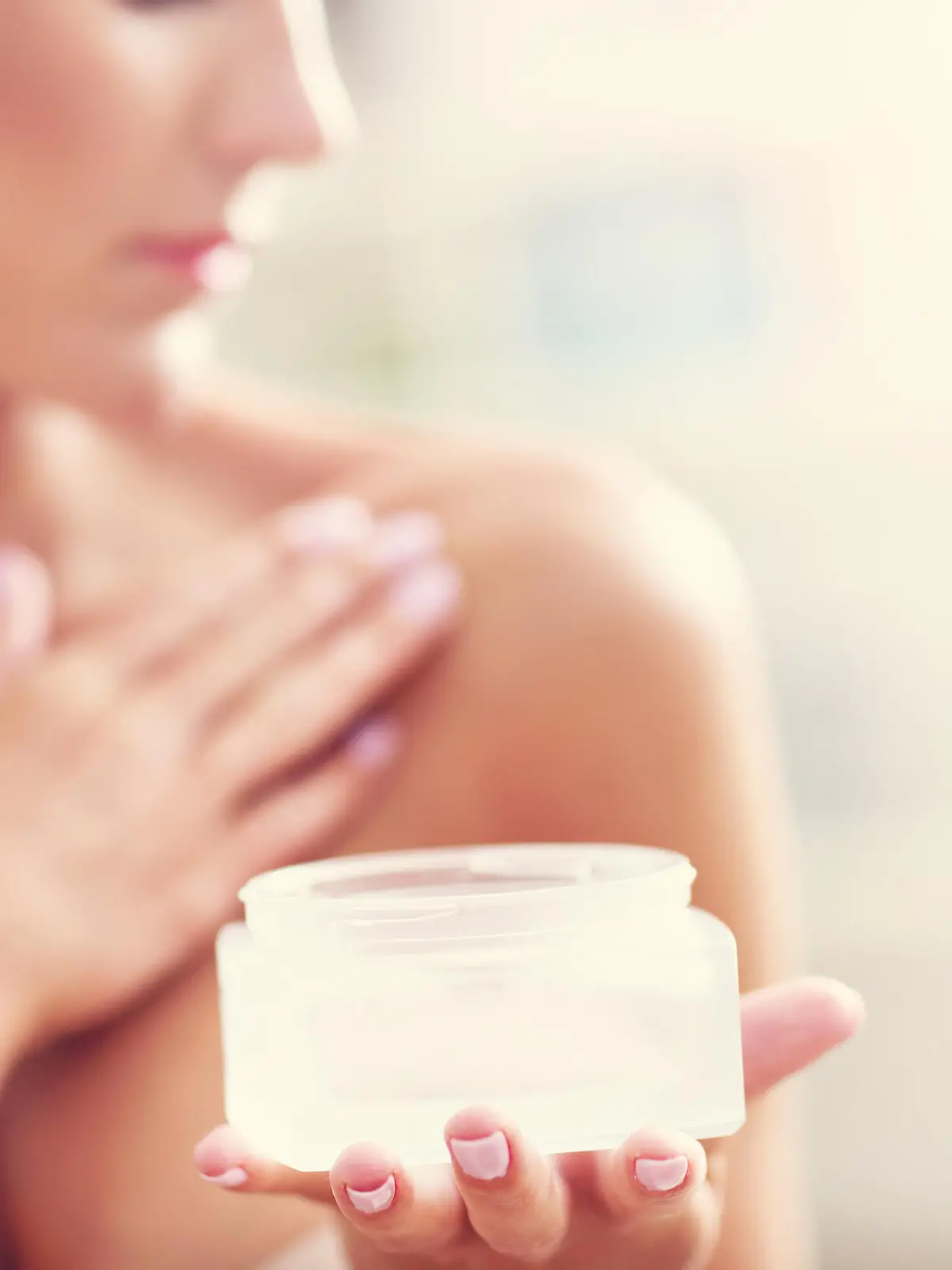 Picture showing fit woman holding lotion over her body