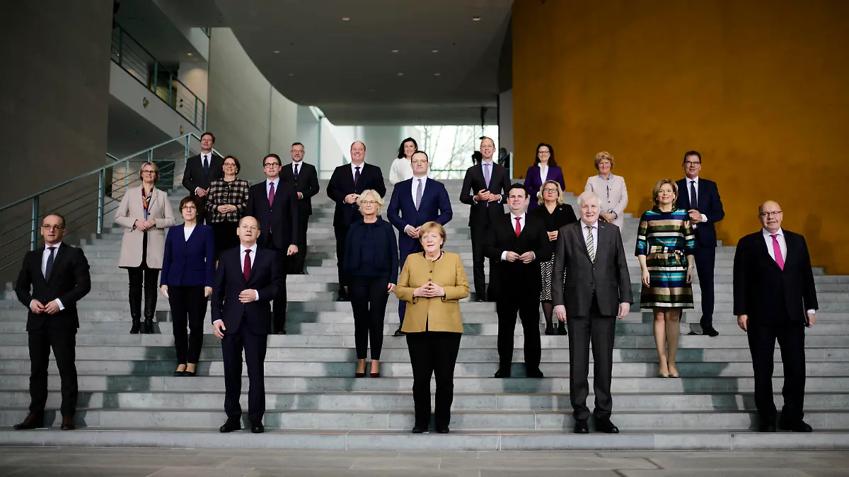 German Chancellor Angela Merkel, center, poses with her government after the cabinet meeting at the chancellery in Berlin, Germany, Wednesday, Nov. 24, 2021. Due to the schedule of coalition talks for a new German government it is probably her last cabinet session as German Chancellor. (AP Photo/Markus Schreiber, Pool)